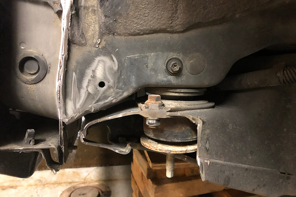 Using a 19mm socket, remove the bolt attaching the sway bar end link to the lower control arm. Do this on both sides so that the sway bar is free to rotate up and out of the way of the lower control arm.